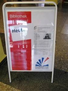 Informatiebord bij de hoofdingang van zwembad en bibliotheek